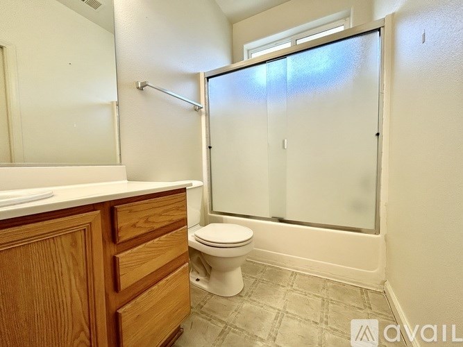 A bathroom with a toilet, sink, and shower.