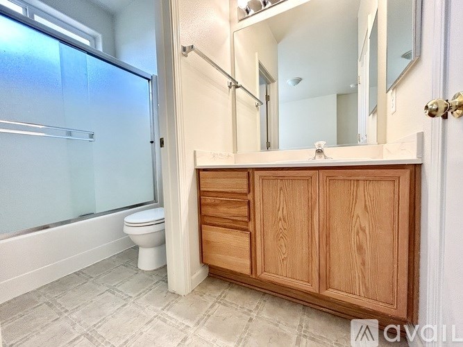 A bathroom with a toilet, sink, and a walk-in shower.