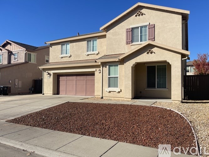A two-story house with a garage and a driveway.