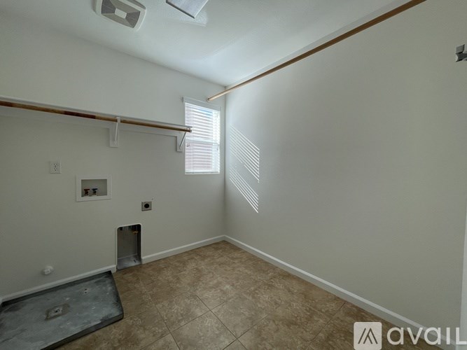 A room with a tiled floor and a window with blinds.