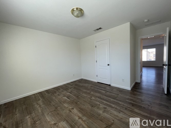 A room with wooden flooring and a white door.