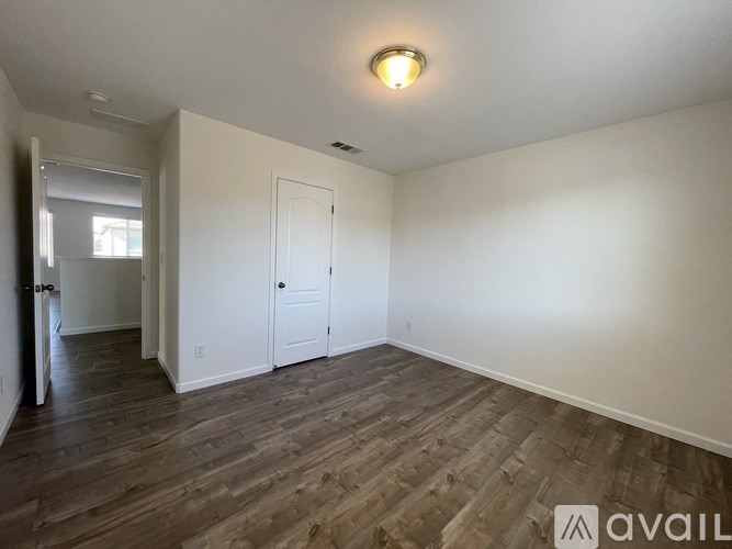 A room with wooden flooring and white walls.
