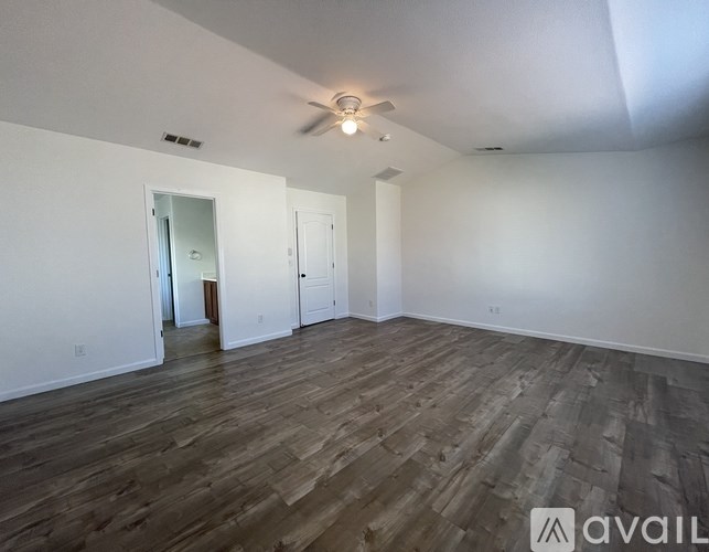 A room with wooden flooring and a ceiling fan.