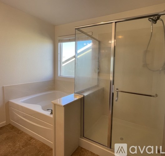 A bathroom with a white tub and a glass shower door.