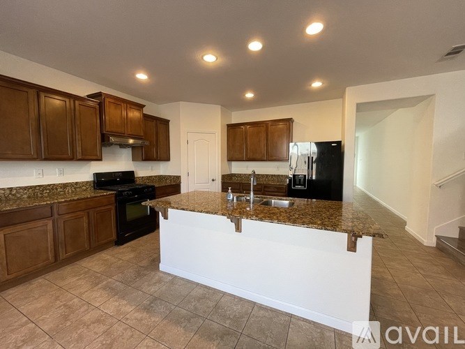 A kitchen with brown cabinets and a granite countertop.