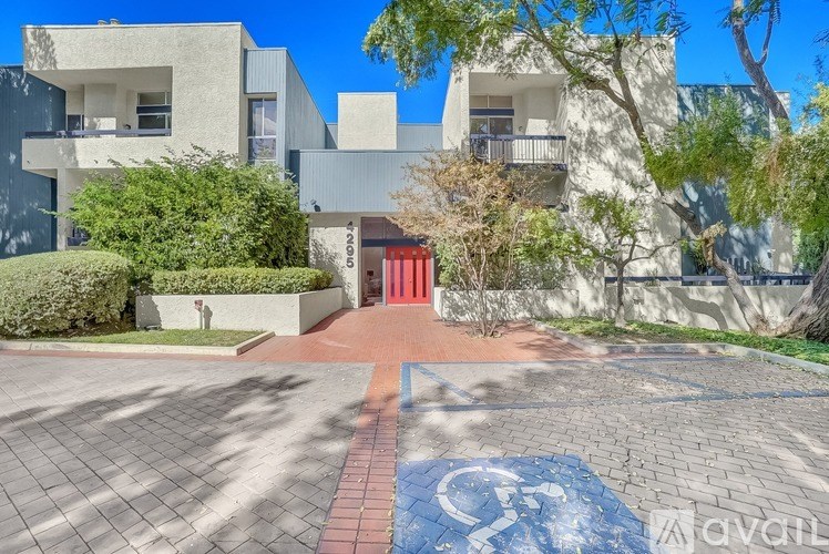 A building with a red door and a handicap parking sign on the ground.