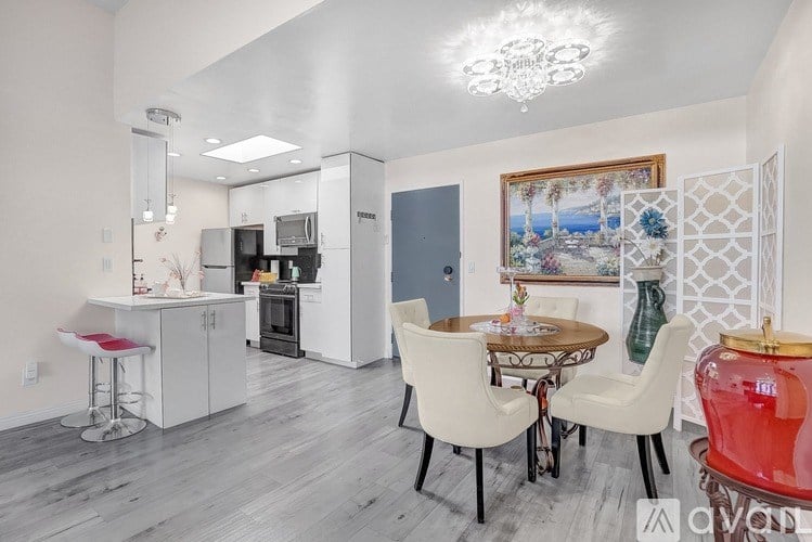 A kitchen with a dining table and chairs.