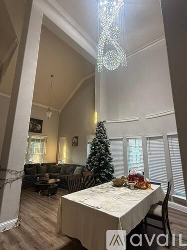A dining room with a table set for a meal and a Christmas tree in the corner.