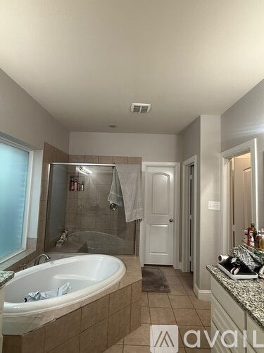 A bathroom with a tub, sink, and mirror.