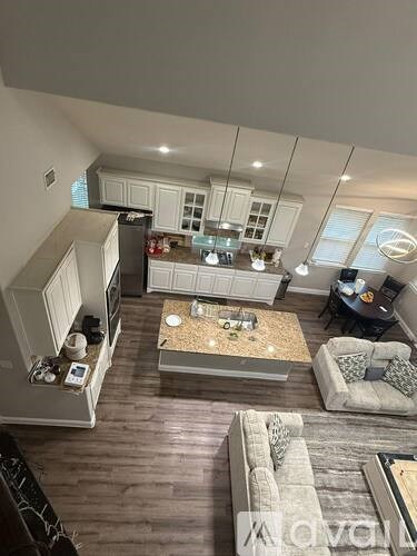 A modern living room with a kitchen area in the background.