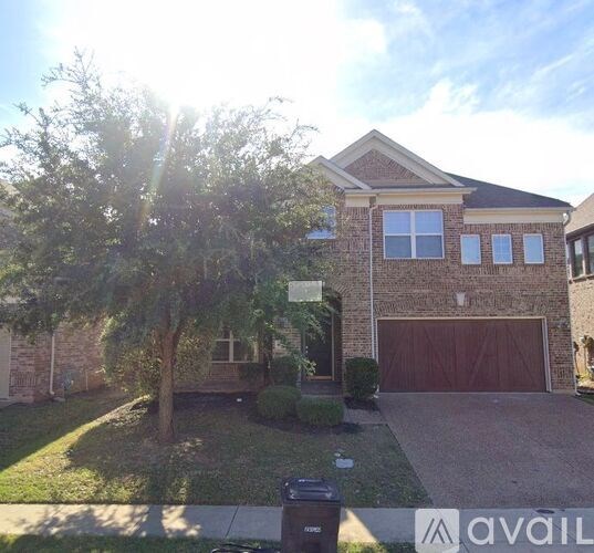 A house with a brown garage door and a tree in front.