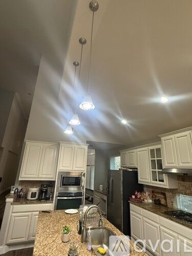 A kitchen with granite countertops and white cabinets.