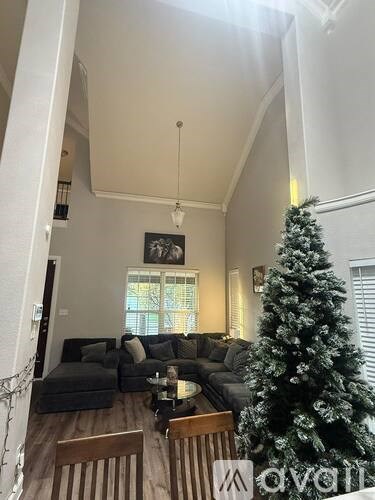 A living room with a Christmas tree and a couch.