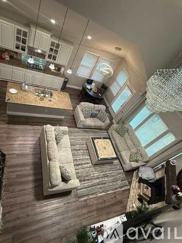A living room with a couch, a coffee table, and a chandelier.