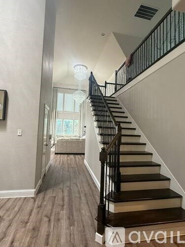A staircase with a black railing and wooden steps leads to a balcony.