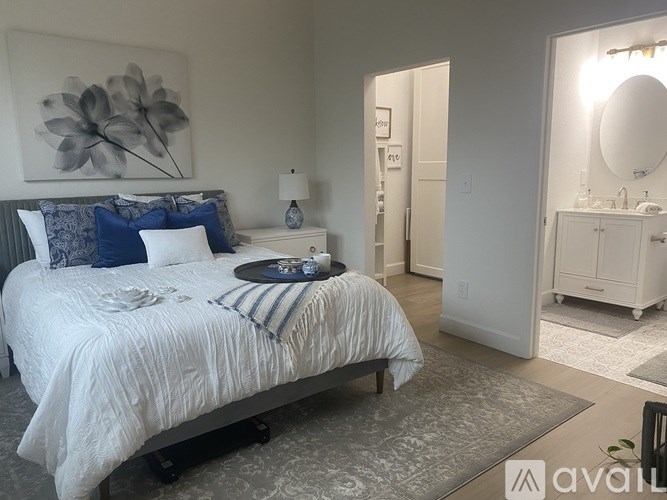 A bedroom with a large bed and a painting on the wall.