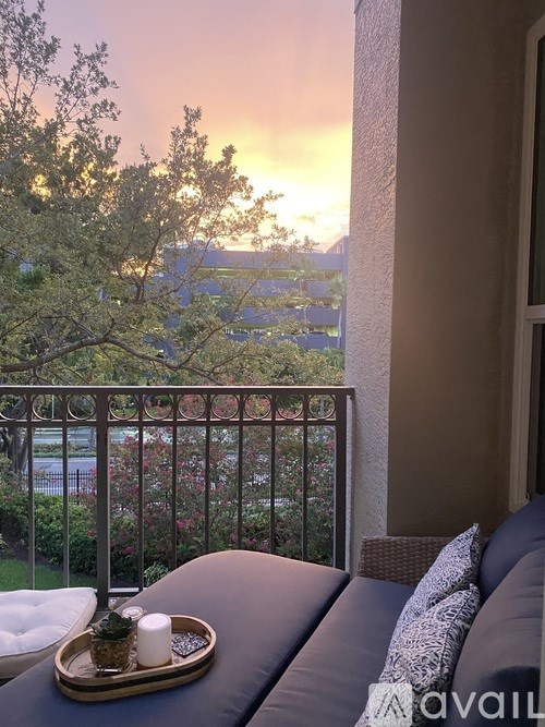A tray with candles and a plant sits on a couch with a view of a sunset.