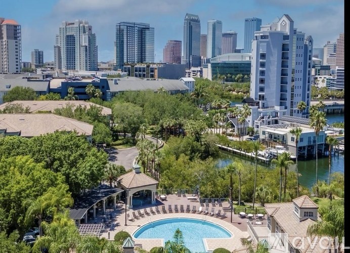 A pool and a house with a backdrop of a city skyline.
