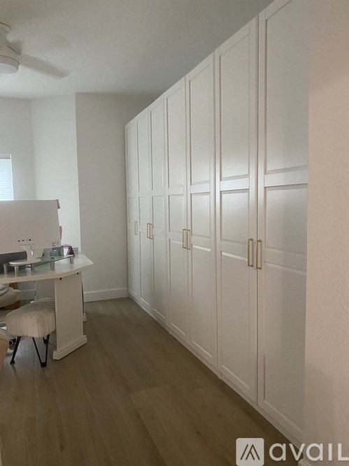 A room with a table and chairs and a wall of cabinets.
