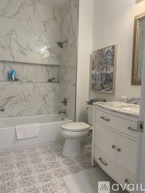 A bathroom with a marble wall and a toilet.