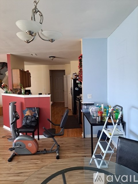 A room with a red counter and a grey exercise bike.