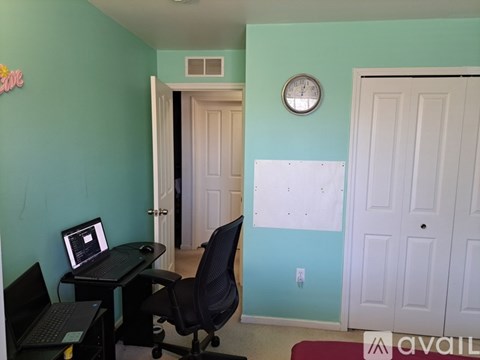 A room with a desk and a laptop on it.