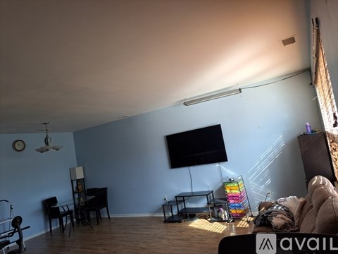 A living room with a television, a couch, and a chair.