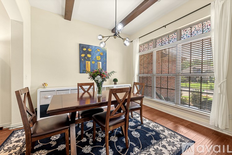 A dining room with a wooden table and chairs.