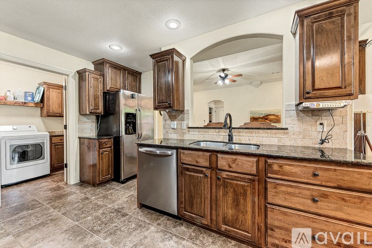 A kitchen with wooden cabinets and a stainless steel refrigerator.