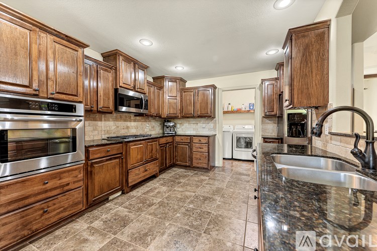 A kitchen with wooden cabinets and a granite countertop.