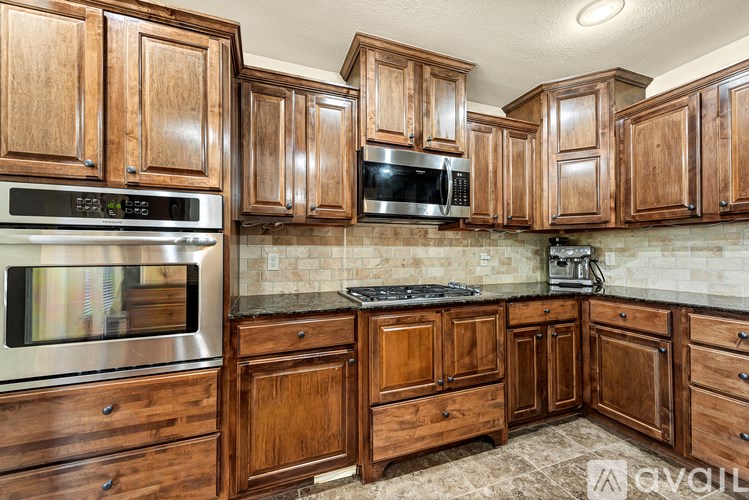 A kitchen with wooden cabinets and a granite countertop.