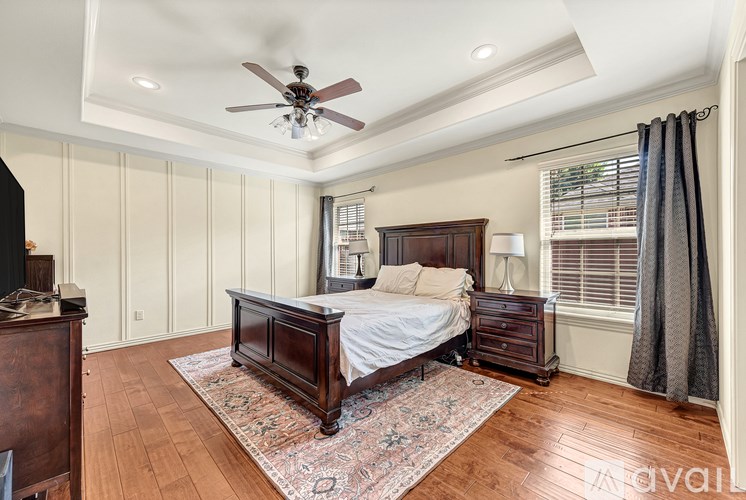 A bedroom with a bed, nightstand, and a ceiling fan.