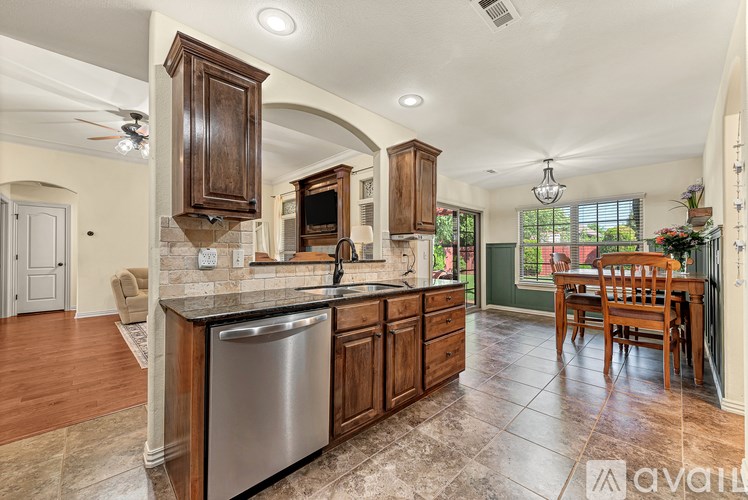 A kitchen with wooden cabinets and a stainless steel dishwasher.