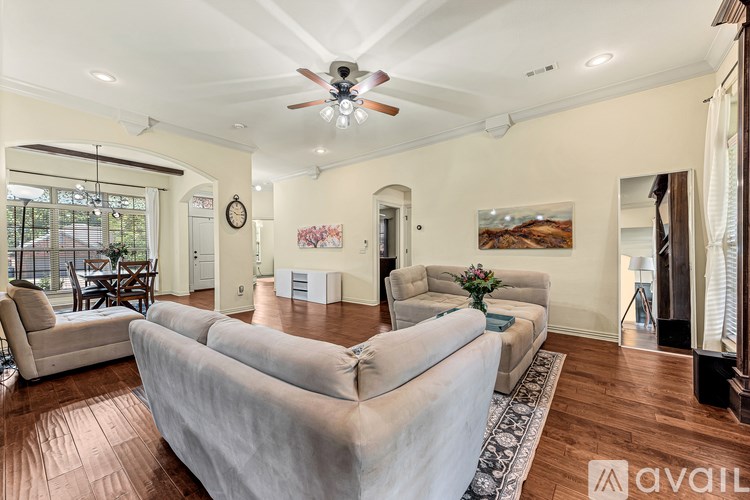 A living room with a large couch and a ceiling fan.