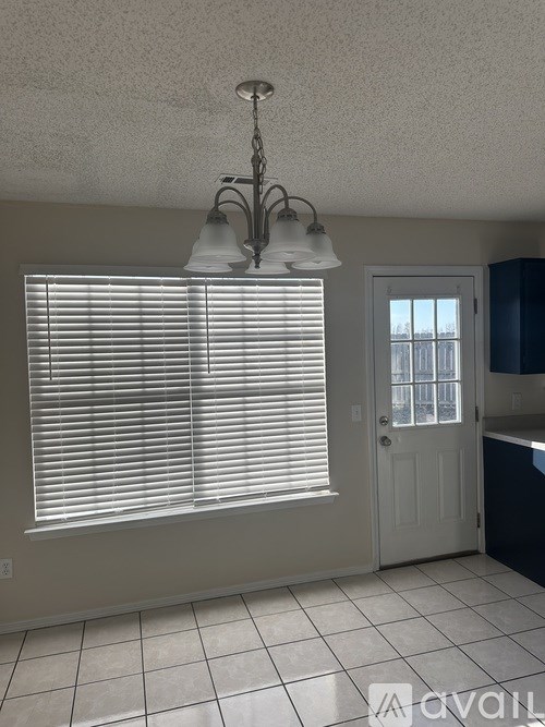 A kitchen with a white door and a chandelier.
