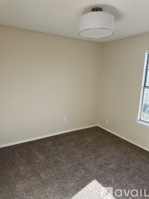 A room with a carpet floor and a window.