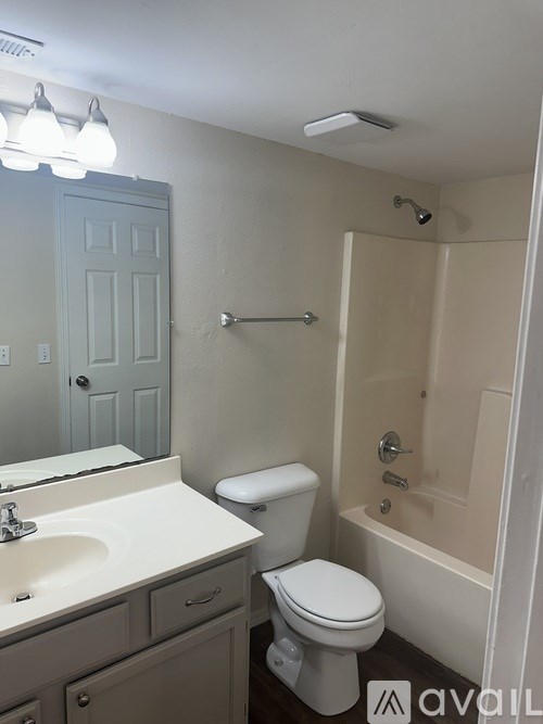 A bathroom with a toilet, sink, and bathtub.