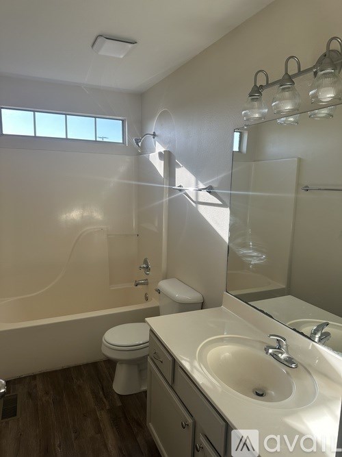 A bathroom with a toilet, sink, and mirror.