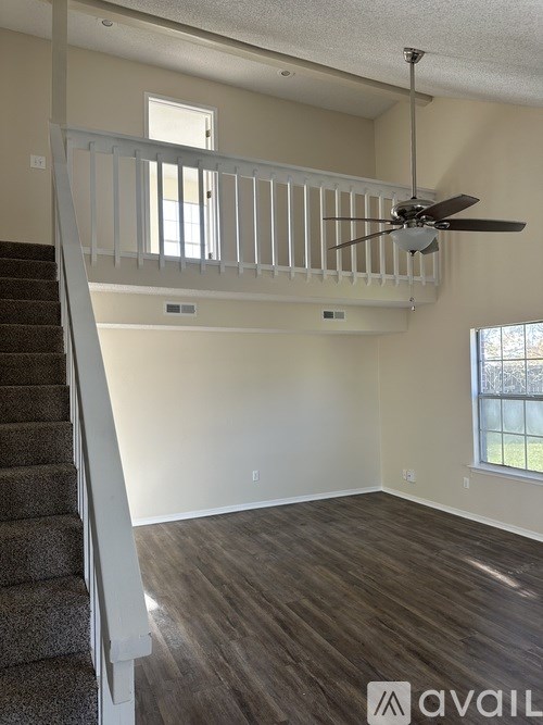 A room with a staircase and a ceiling fan.