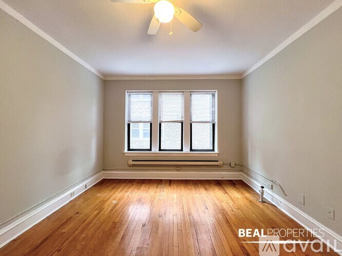 A room with wooden floors and a window with blinds.