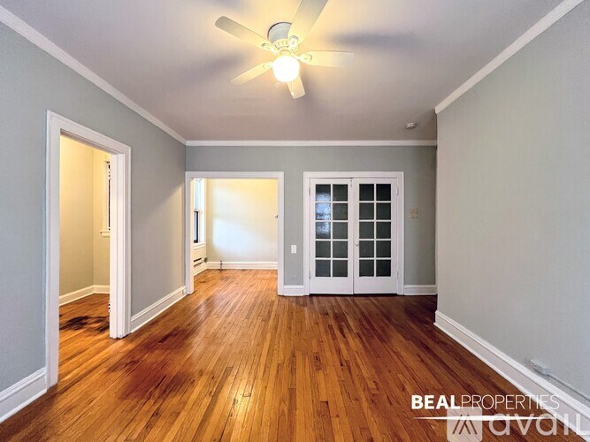 A room with wooden floors and a ceiling fan.