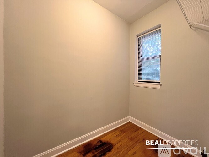 A room with a window and wooden flooring.