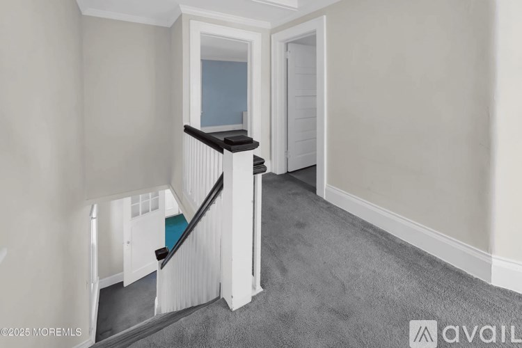 A hallway with a staircase leading to a second floor.