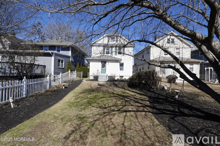 A white house with a tree in front of it.