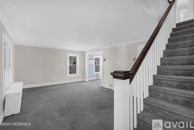 A spacious room with a staircase leading to the upper floor.