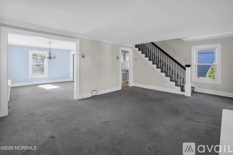 A spacious room with a staircase leading to the upper floor.