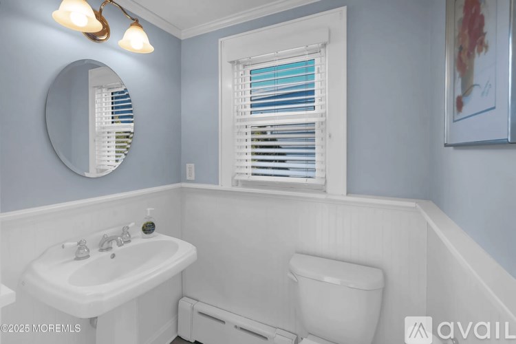 A bathroom with a white sink and toilet.