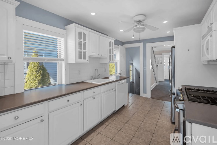A kitchen with white cabinets and a brown countertop.