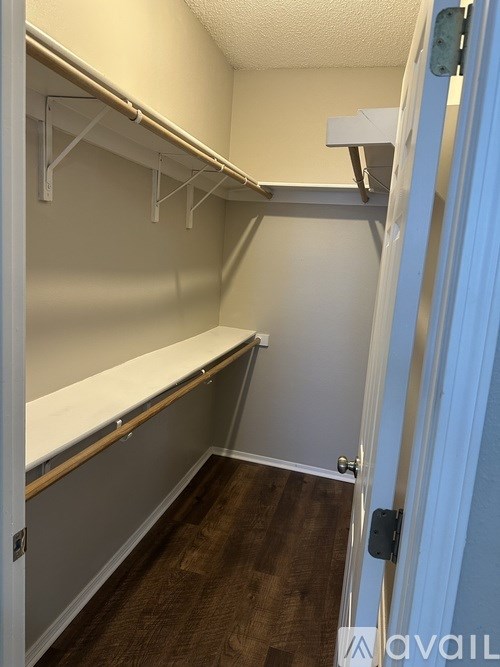 A walk-in closet with white shelves and a blue door.