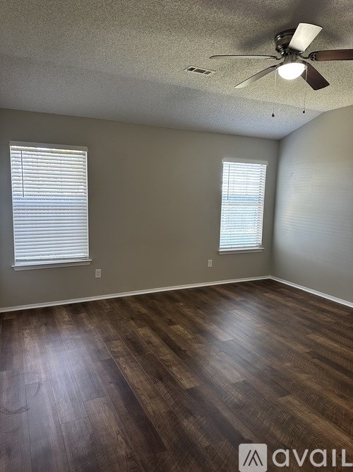 A room with wooden flooring and a ceiling fan.